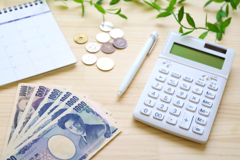 シングルマザーの家計管理と節約のイメージ（電卓とお金）
