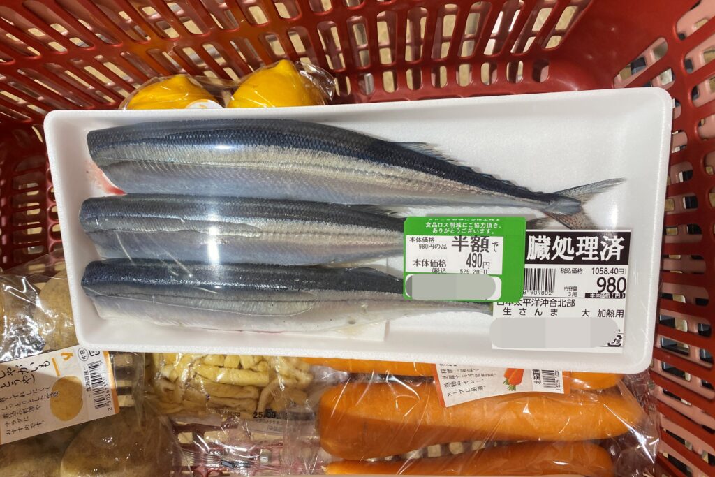 スーパーで半額のサンマが入っている買い物カゴ